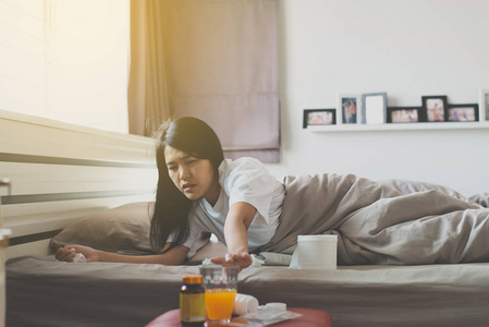 女人拿起手上的药丸或胶囊和一杯水