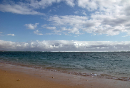 美丽的沙滩，地平线上有云团聚岛