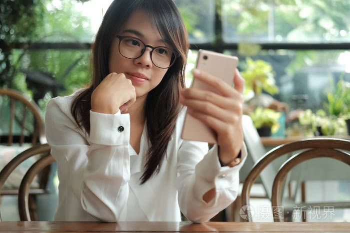 亚洲妇女使用手机与前摄像头的自拍和s