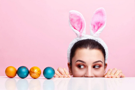 快乐的年轻女子戴着兔子耳朵和复活节彩蛋