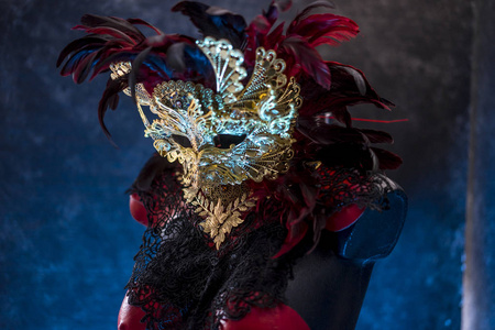 威尼斯红色面具和红色胸衣与黄金和黑色花边织物在金属胸板上。 派对或服装会议的手工馅饼