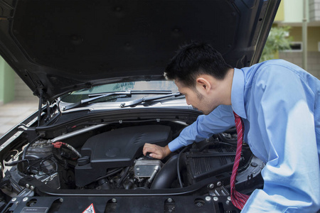 商人打开引擎盖，试图修理一辆故障车