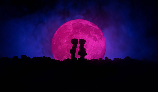 情人节的装饰理念.爱情侣的剪影对月亮的亲吻照片