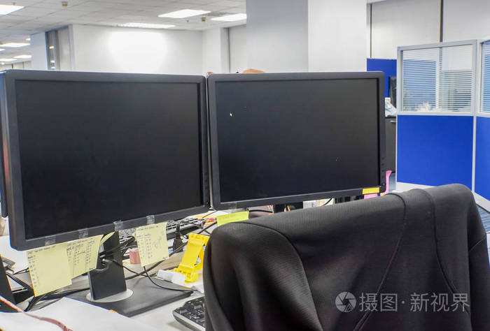 两台电脑连接办公室显示器和员工椅子