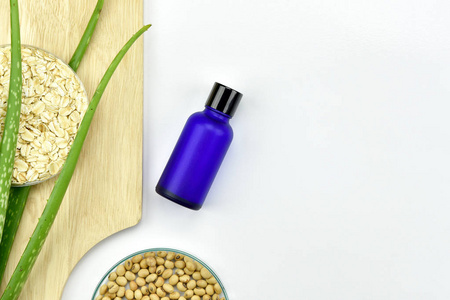 带有绿色草本叶子的化妆品瓶容器, 用于品牌模拟的空白标签照片