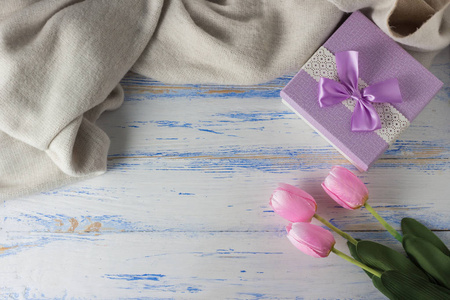 粉红色的郁金香, 围巾和礼品盒上的白色木质背景。有限公司