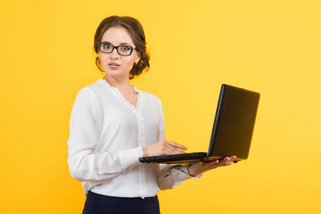 年轻的黑发女人拿着现代笔记本电脑