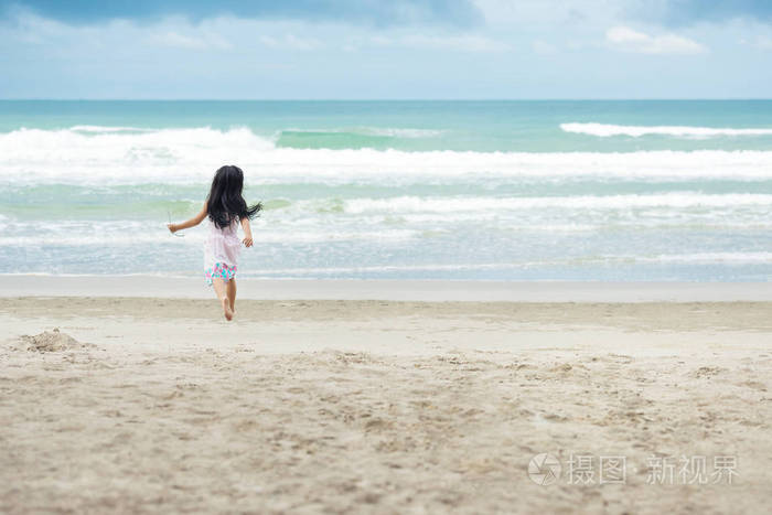在海滩上奔跑的白色衣裳的小孩子女孩