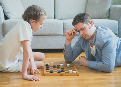 父亲和女儿玩跳棋棋盘游戏