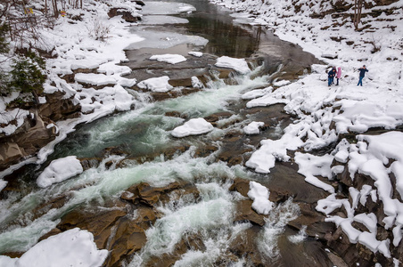 冬季景观。山上的河流从岩石中流出。雪和山河