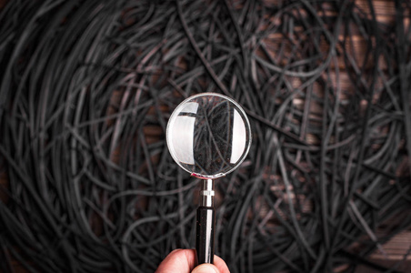 黑色皮带上方男性手持放大镜的局部视图照片