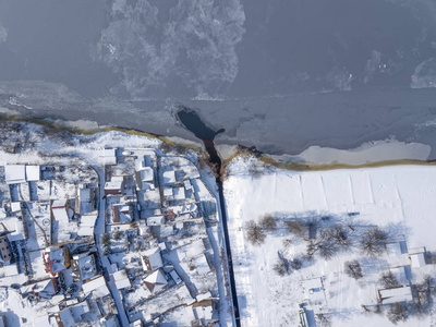 空中无人机视图的道路和房子冬季景观。冬天的城市街道从鸟瞰图。积雪覆盖的建筑物的顶部透视。道路, 草坪, 汽车和树木覆盖的积雪从上