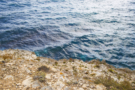 黄色岩石纹理和蓝色蔚蓝海水的背景。 塔克汉库特西犯罪半岛角