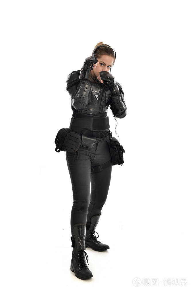 女士兵穿着黑色战术盔甲的全长肖像,孤立在白色工作室背景上.