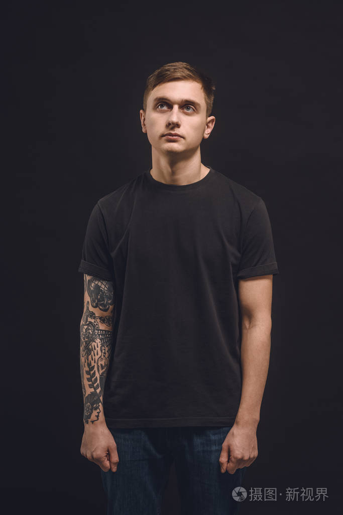 有纹身的年轻人手臂被隔离在黑色上
