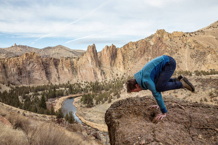 人在平衡他的手。 拍摄于美国俄勒冈州史密斯岩石雷德蒙德。 概念冒险假期和旅行