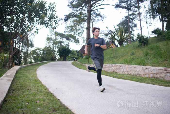 亚洲青年运动员早上在公园跑步