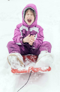 快乐的小女孩坐在雪橇上选择性专注