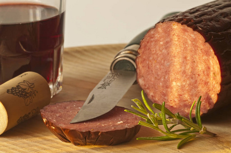 用刀子把美味的腊肠肉贴在木板上