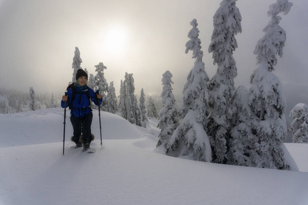 年轻的冒险的白种人女人在白雪覆盖的山上滑雪。 摄于西摩山北温哥华不列颠哥伦比亚省加拿大。