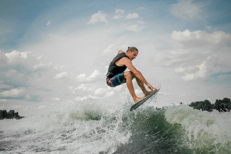 年轻的家伙 wakesurfing 在河上的木板上