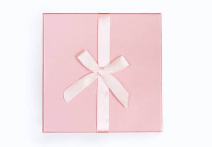 粉红色礼品盒与丝带和蝴蝶结隔离在白色背景上。 顶部视图