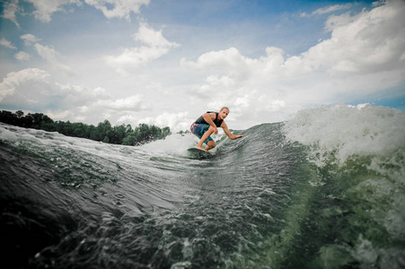 年轻人 wakesurfing 在河上的木板上