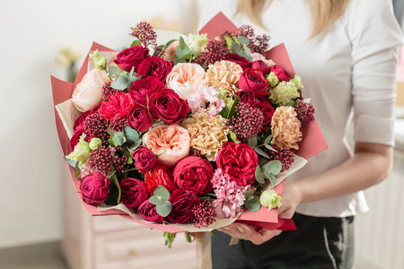 高红色的花束。美丽的豪华的混合花在女人的手。花店种花的工作