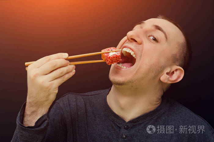 男人用筷子吃面包张开嘴巴黑色背景