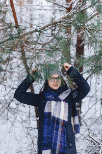 可爱的女孩在玻璃松树树枝下冬季在雪