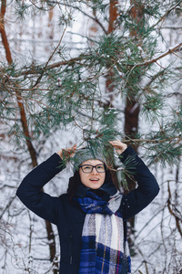 可爱的女孩在玻璃松树树枝下冬季在雪