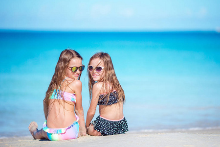 两个小快乐的女孩在热带海滩玩得很开心