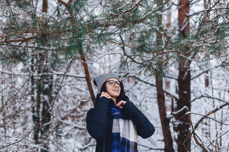 可爱的女孩在玻璃松树树枝下冬季在雪