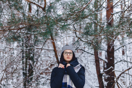 可爱的女孩在玻璃松树树枝下冬季在雪