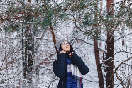 可爱的女孩在玻璃松树树枝下冬季在雪