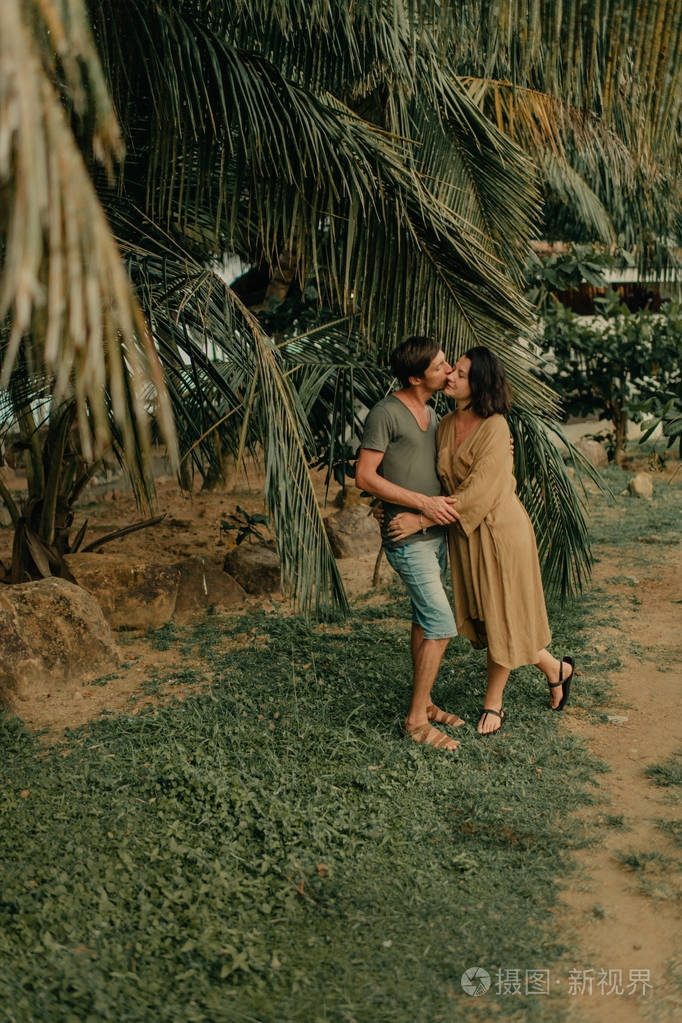 一男一女拥抱在海边的棕榈树下