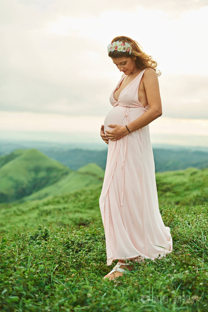 怀孕妇女站立在草