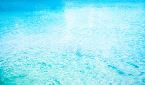 蓝色阳光明媚的水纹理。 热带完美蓝绿色海滩