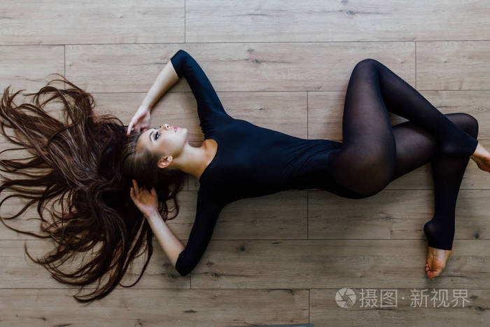 美丽的年轻模特芭蕾舞演员躺在 inon 地板上。顶部视图