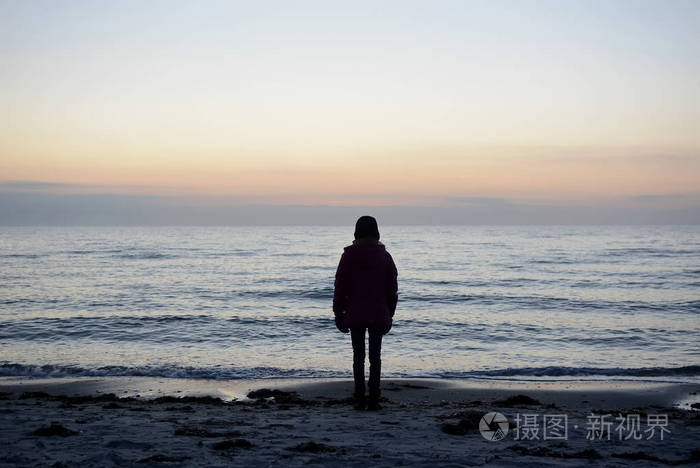 孤独的年轻女孩看着大海