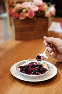 在木桌上用人造花束手工制作蓝莓芝士蛋糕