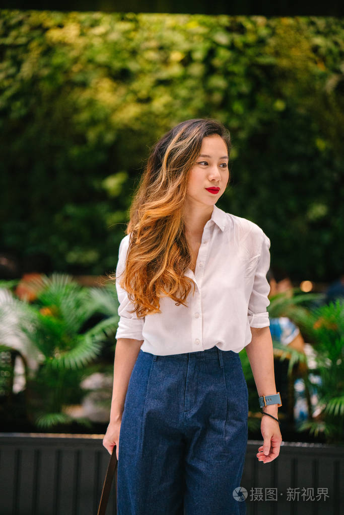 一位年轻的新加坡籍中国亚洲女性高管在城市户外散步的肖像.