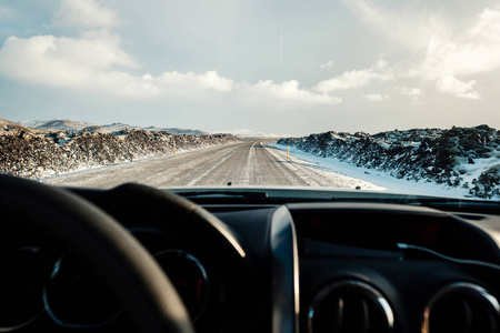 在冰岛的冬天开车。 吹雪过马路。 冰岛冬季驾驶条件困难。 晴朗但多风的一天，典型的冰岛路线问题。 冰岛安全驾驶。