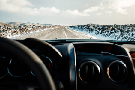 在冰岛的冬天开车。 吹雪过马路。 冰岛冬季驾驶条件困难。 晴朗但多风的一天，典型的冰岛路线问题。 冰岛安全驾驶。