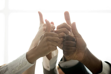 多种族团队的双手伸出大拇指,竖起手指,激励不同的企业团体,如庆祝
