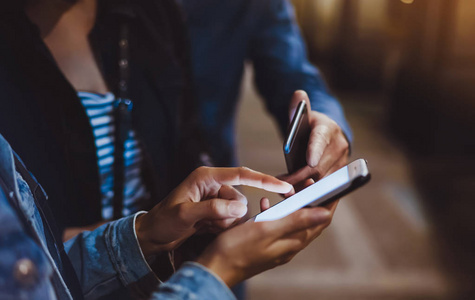 wifi,互联网概念博客,博客们一起用手指指着屏幕上的智能手机,在夜间