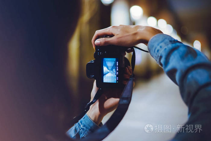 时尚徒步旅行者拍照,手拿相机拍摄夜景城市背景,摄影女孩在旅途中享受