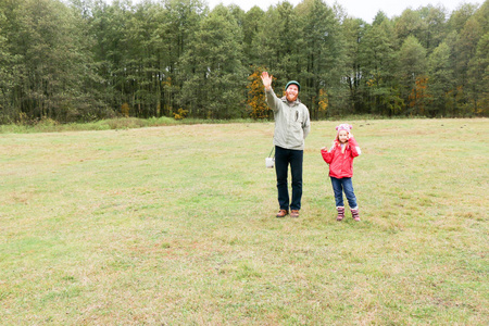 年轻的父亲在田野里和他的女儿玩耍