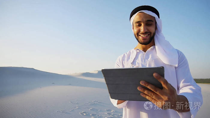 成功的阿拉伯商人手里拿着和使用平板电脑，s