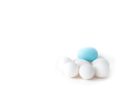 一张特写照片，一堆真正的鸡蛋和一个浅蓝色塑料复活节鸡蛋在顶部隔离在白色背景上，制作了一个美丽的节日壁纸与白色开放的空间周围的图像